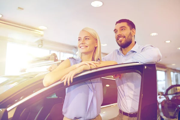 Casal feliz comprar carro em auto show ou salão — Fotografia de Stock