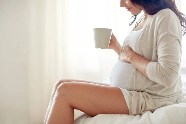 Primer plano de la mujer embarazada con taza de té en casa — Foto de Stock