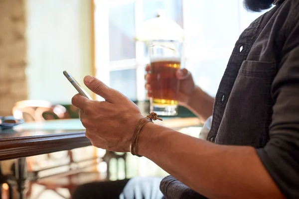 Close up de homem com smartphone e cerveja no pub — Fotografia de Stock