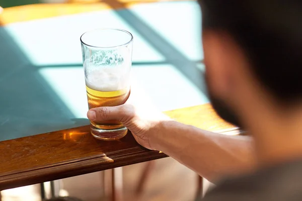 Nahaufnahme eines Mannes, der in einer Bar oder Kneipe Bier trinkt — Stockfoto