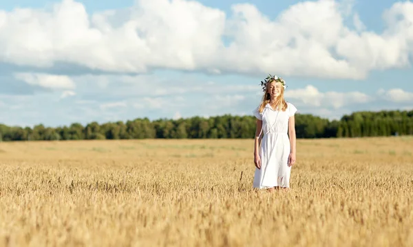 Feliz joven en corona de flores en el campo de cereales — Foto de Stock