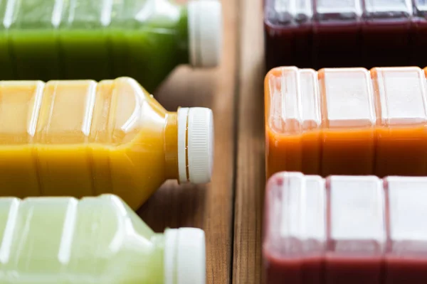 Garrafas com diferentes sucos de frutas ou vegetais — Fotografia de Stock