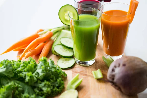 Copos com diferentes sucos de frutas ou vegetais — Fotografia de Stock