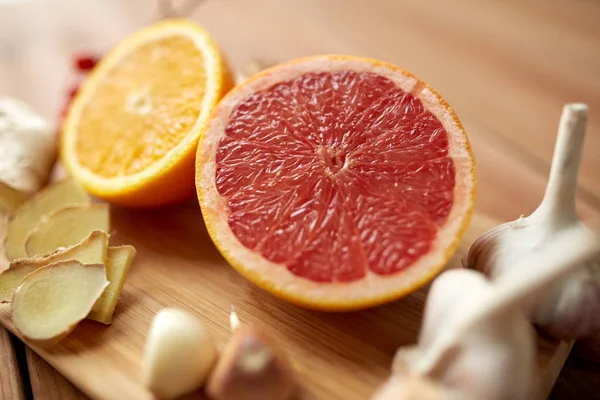 Buah jeruk, jahe dan bawang putih di atas kayu — Stok Foto