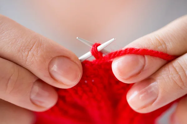 Primer plano de las manos tejiendo con agujas e hilo — Foto de Stock