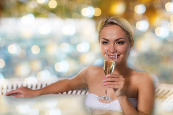 Mujer feliz bebiendo champán en la piscina —  Fotos de Stock