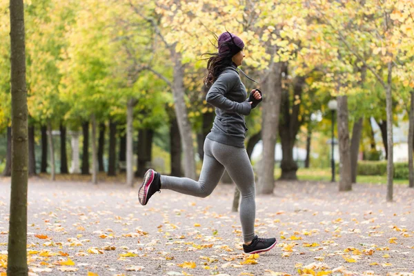 Крупним планом молода жінка біжить в осінньому парку — стокове фото