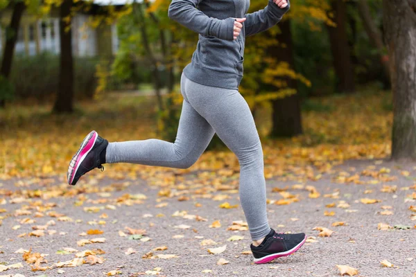 Primer plano de la joven corriendo en el parque de otoño —  Fotos de Stock
