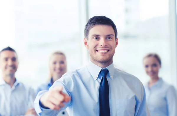 Smiling businessman with colleagues in office — Stock Photo, Image