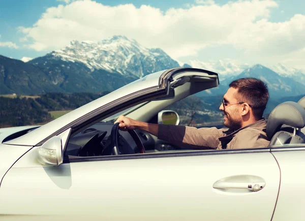 Homem feliz dirigindo carro cabriolet sobre montanhas — Fotografia de Stock