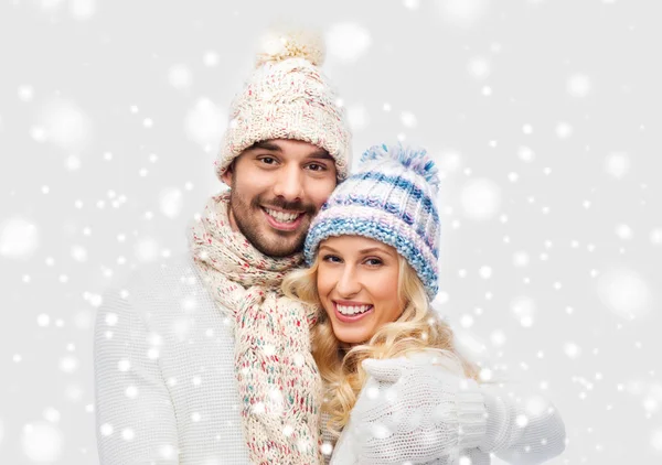 Усміхнена пара в зимовому одязі обіймається — стокове фото