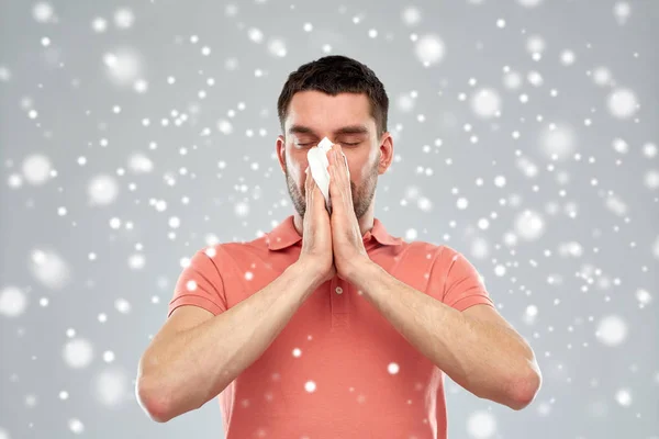 Kranker Mann mit Papierwischer weht Nase über Schnee — Stockfoto