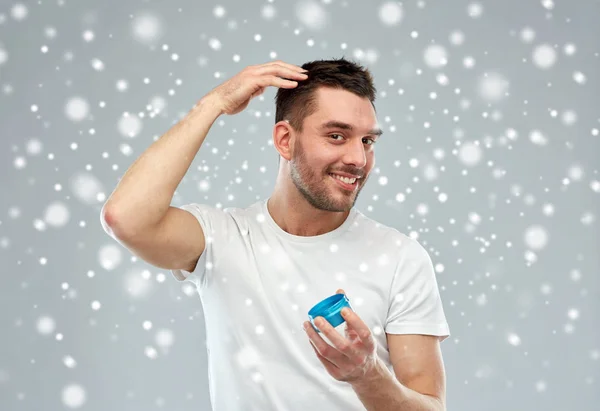 Happy young man styling his hair with wax or gel — Stock Photo, Image