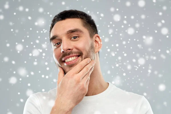 Jovem feliz tocando seu rosto ou barba — Fotografia de Stock
