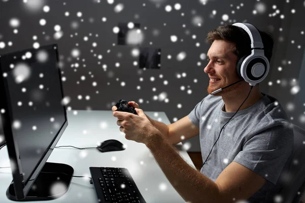 Homem em fone de ouvido jogando jogo de computador em casa — Fotografia de Stock