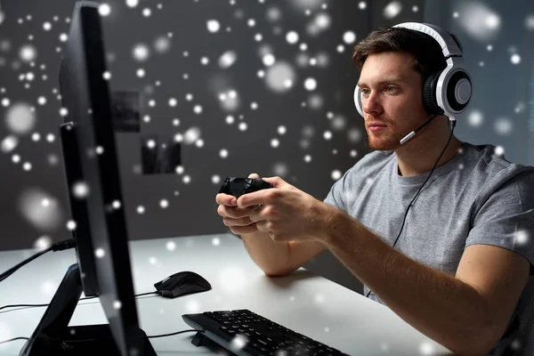 Hombre en auriculares jugando videojuego de ordenador en casa — Foto de Stock