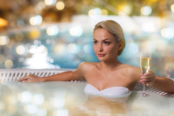 Mulher feliz bebendo champanhe na piscina — Fotografia de Stock