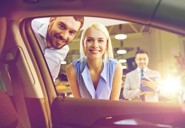 Coppia felice con concessionario auto in salone o salone di auto — Foto Stock