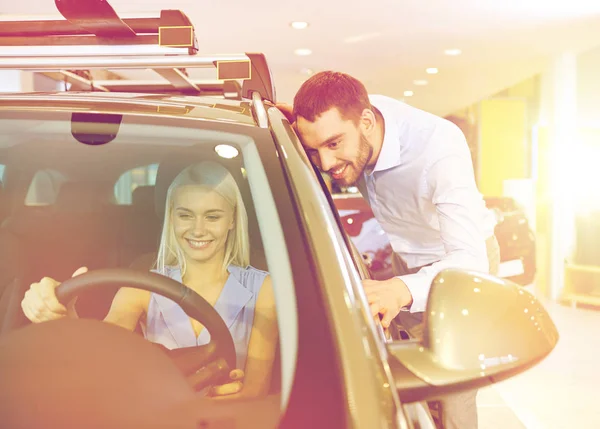 Feliz pareja comprando coche en auto show o salón —  Fotos de Stock