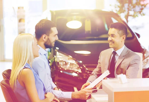 Feliz pareja con concesionario de coches en auto show o salón — Foto de Stock