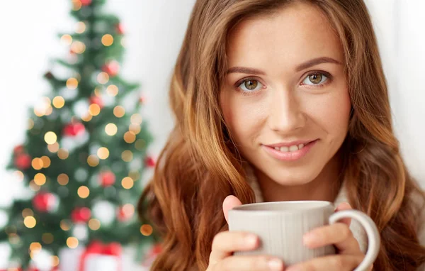 Primer plano de la mujer con taza de té sobre el árbol de Navidad — Foto de Stock