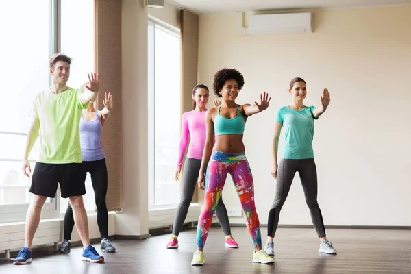 Groep van lachende mensen dansen in de sportschool of studio — Stockfoto