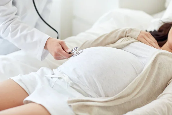 Medico con stetoscopio e donna incinta — Foto Stock