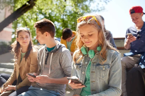 Amigos adolescentes com smartphone e fones de ouvido — Fotografia de Stock