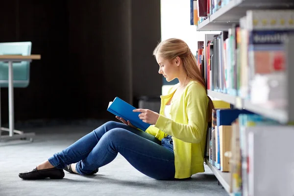 Estudante do ensino médio menina leitura livro na biblioteca — Fotografia de Stock