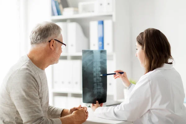 Arzt mit Wirbelsäulenröntgen und Senior im Krankenhaus — Stockfoto