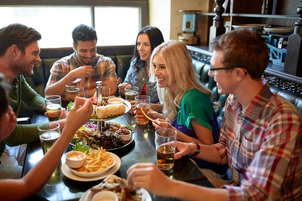 Amigos jantar e beber cerveja no restaurante — Fotografia de Stock