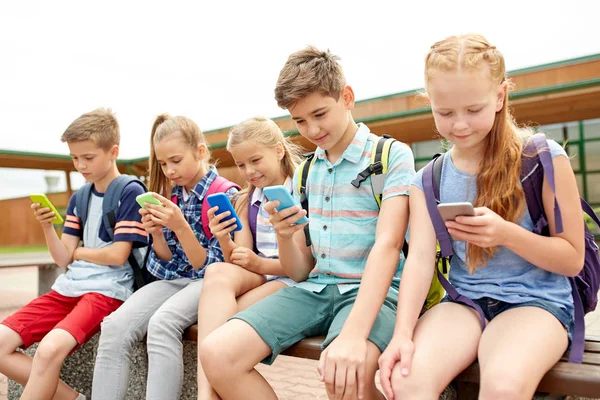 Estudiantes de primaria con smartphones — Foto de Stock