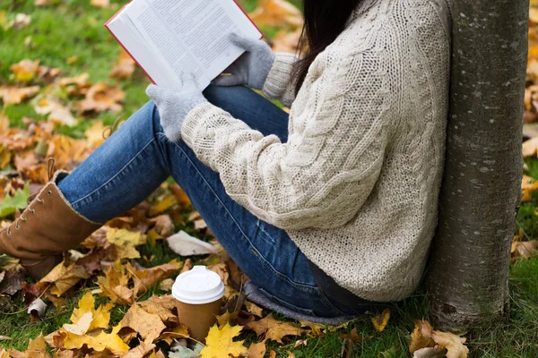 Donna con libro bere caffè nel parco autunnale — Foto Stock