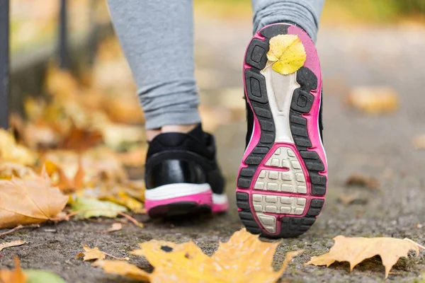 Närbild av kvinna fötter bär sneakers i höst — Stockfoto