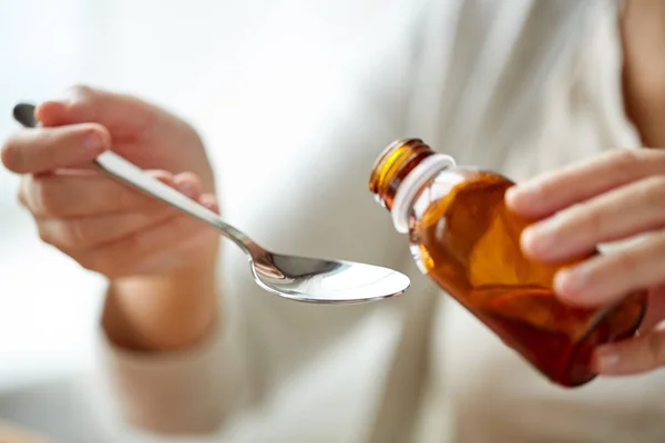 Γυναίκα ρίχνει φαρμακευτική αγωγή από το μπουκάλι στο κουτάλι — Φωτογραφία Αρχείου