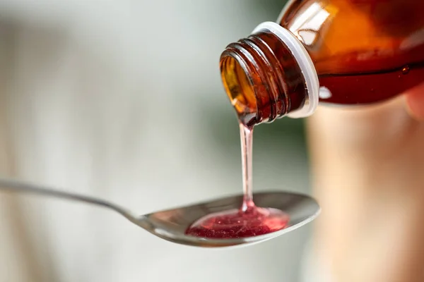 Medication or antipyretic syrup and spoon — Stock Photo, Image