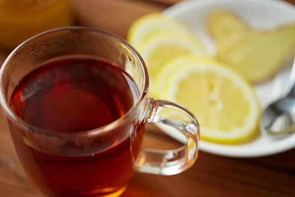 Чашка чая с лимоном и имбирем на тарелке — стоковое фото
