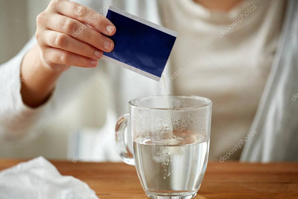 Woman pouring medication into cup of water Stock Photo by ©Syda_Productions  130480918