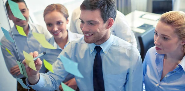 Smiling business people with marker and stickers — Stock Photo, Image