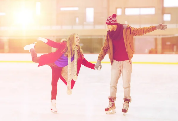 Couple heureux tenant la main sur la patinoire — Photo