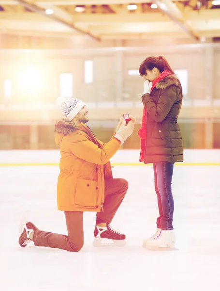 Feliz pareja con anillo de compromiso en pista de patinaje — Foto de Stock
