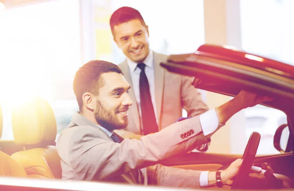 Homem feliz com negociante de carro em auto show ou salão de beleza — Fotografia de Stock