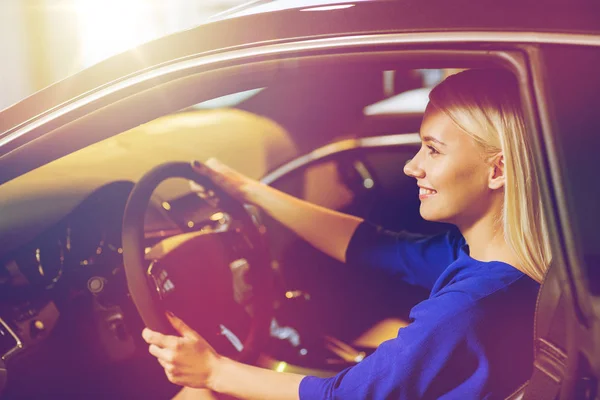 Glückliche Frau im Auto in Autoshow oder Salon — Stockfoto