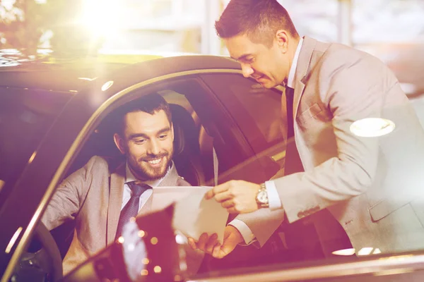 Happy man with car dealer in auto show or salon — Stock Photo, Image