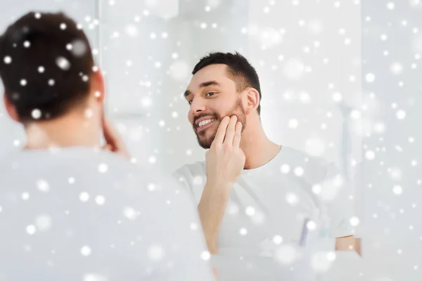 Felice giovane uomo che applica la crema al viso in bagno — Foto Stock