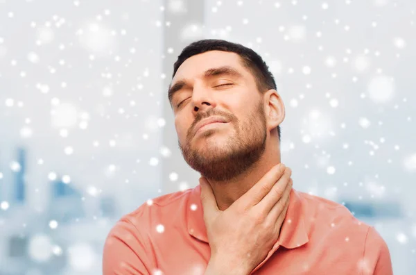 Homem infeliz que sofre de dor de garganta sobre a neve — Fotografia de Stock