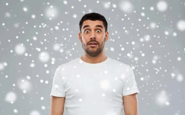 Homme effrayé en t-shirt blanc sur la neige — Photo