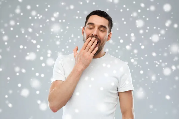 Hombre bostezando cansado sobre la nieve —  Fotos de Stock