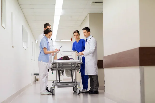 Medics with woman on hospital gurney at emergency — Stock Photo, Image