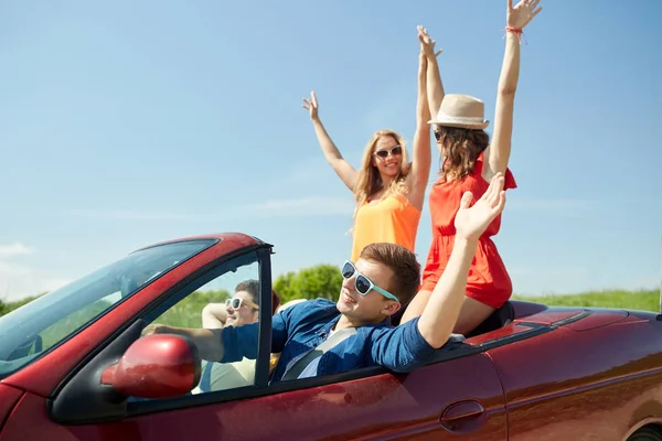 Teman-teman bahagia mengemudi dalam mobil ungu di negara — Stok Foto